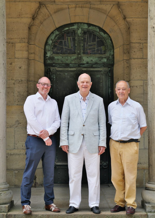 Der dreiköpfige Stiftungsvorstand im Juni 2026 vor dem Eingang zum Turm der Kirche (von links nach rechts): Nikolaus Wolf, Joachim Goerke-von Stockert, Christoph Haehling von Lanzenauer